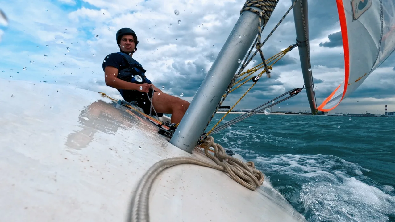 A SeaQuest sailor trimming a sail from the cockpit