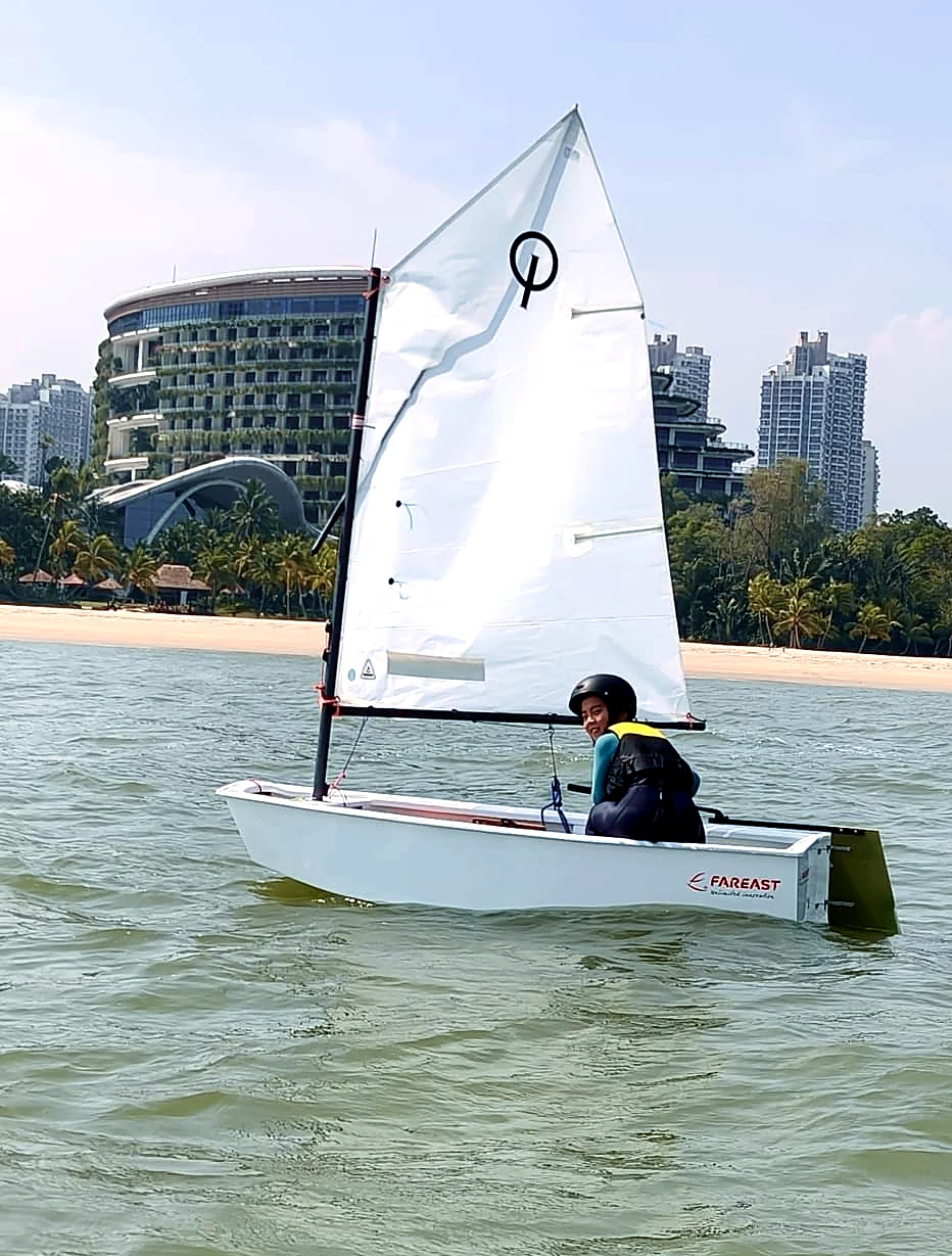 A SeaQuest sailor in an Optimist dinghy at Forest City